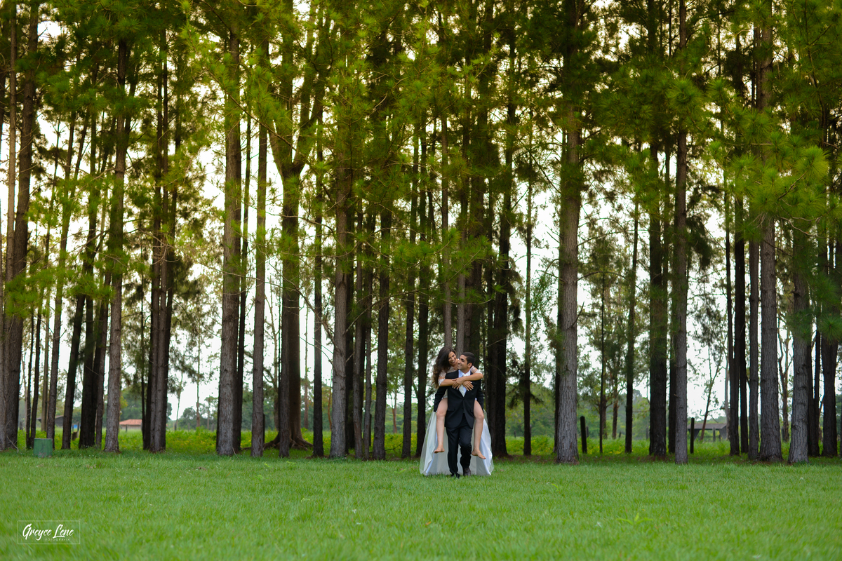 noivo correndo carregando a noiva em suas costas enquanto se divertem e sorriem sessao externa em porto velho rondonia 
