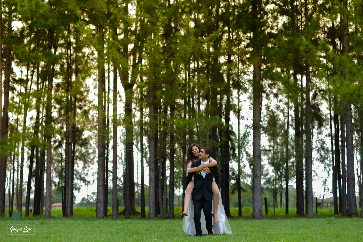 noivo correndo carregando a noiva em suas costas enquanto se divertem e sorriem e se olham sessao externa em porto velho rondonia 