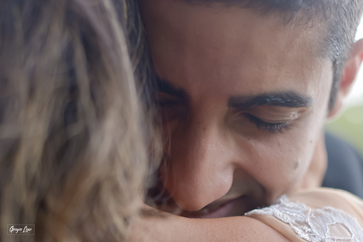close no rosto do noivo que esta de olhos fechado sorrindo e sentido o perfume no pescoço de sua noiva sessão externa porto velho rondonia 