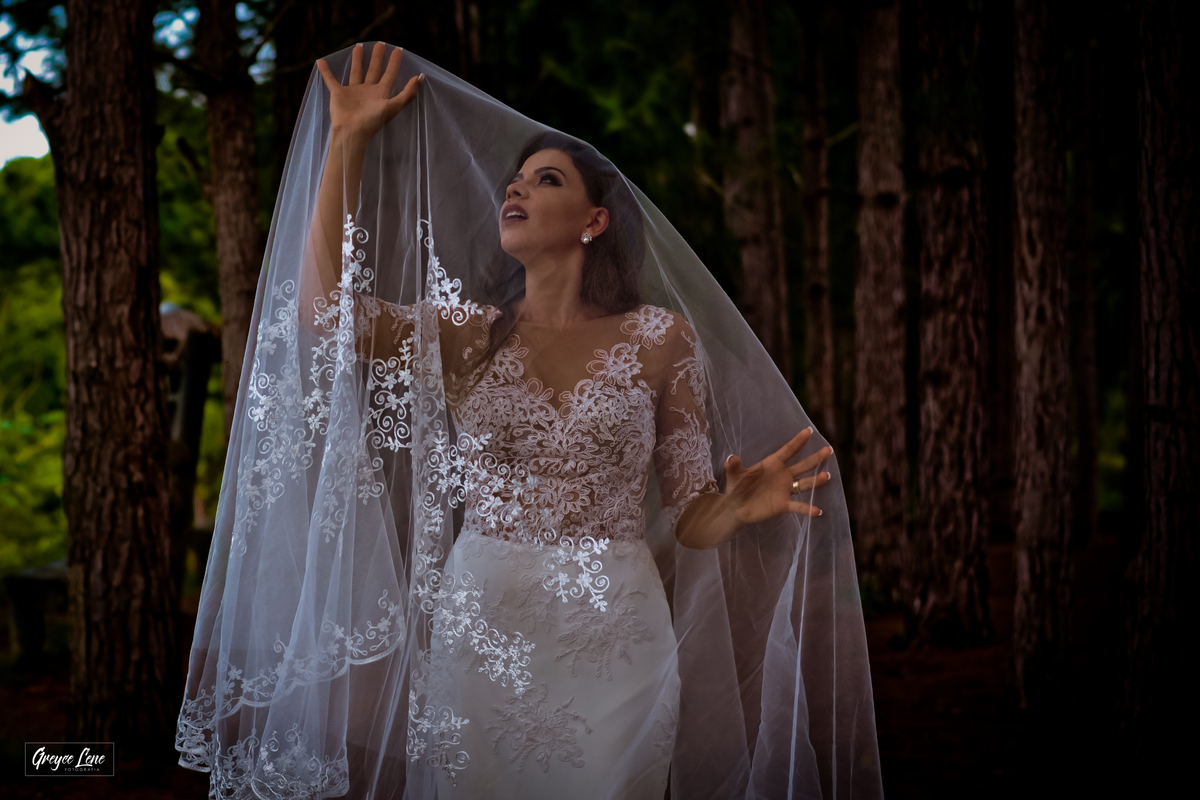 noiva entre arvores embaixo de seu véu olhando para cima sessao externa porto velho rondonia