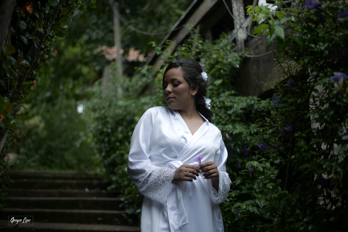 noiva ao ar livre em escada durante o makingof olhando para o lado 