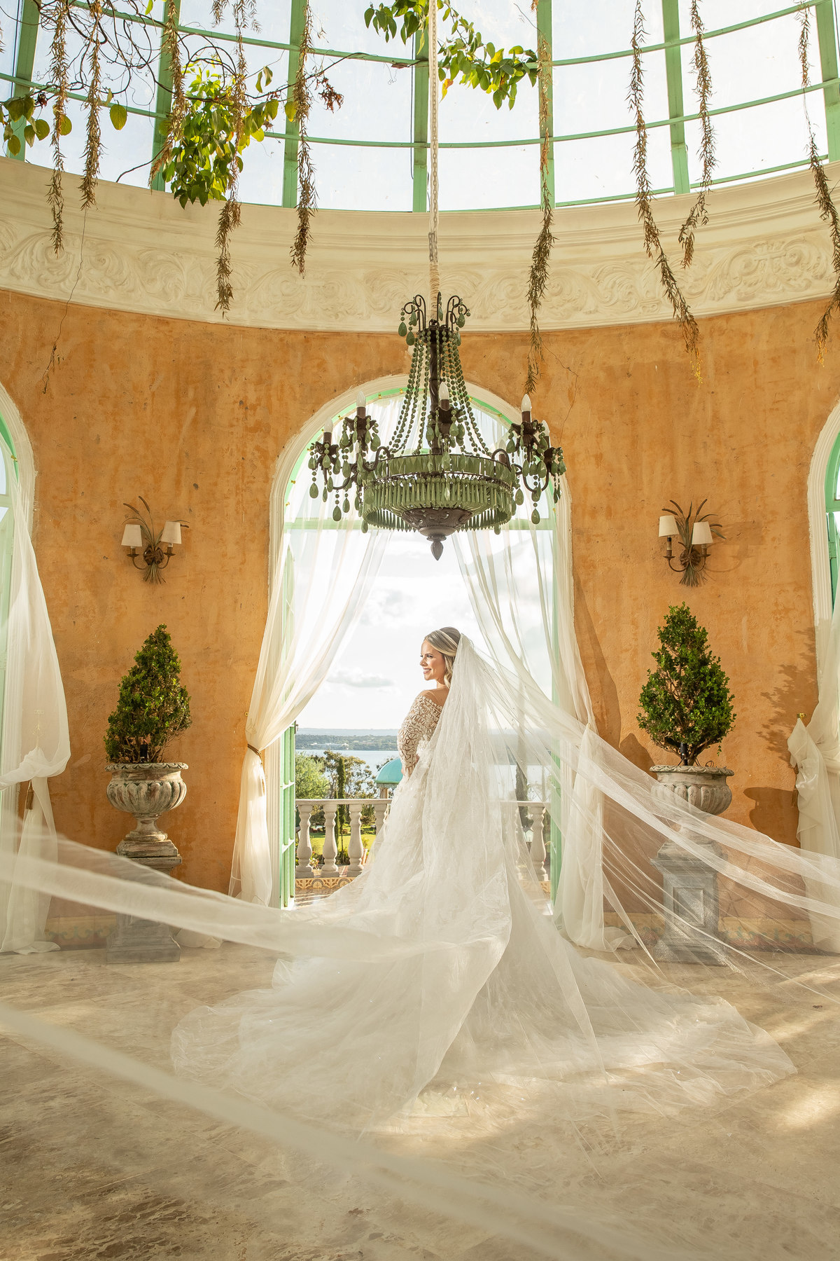 Uau...que fotão! A noiva está de costas, com as mãos na cintura, todo o seu véu para trás voando e ela sorrindo toda feliz, tudo se encaixa perfeitamente.