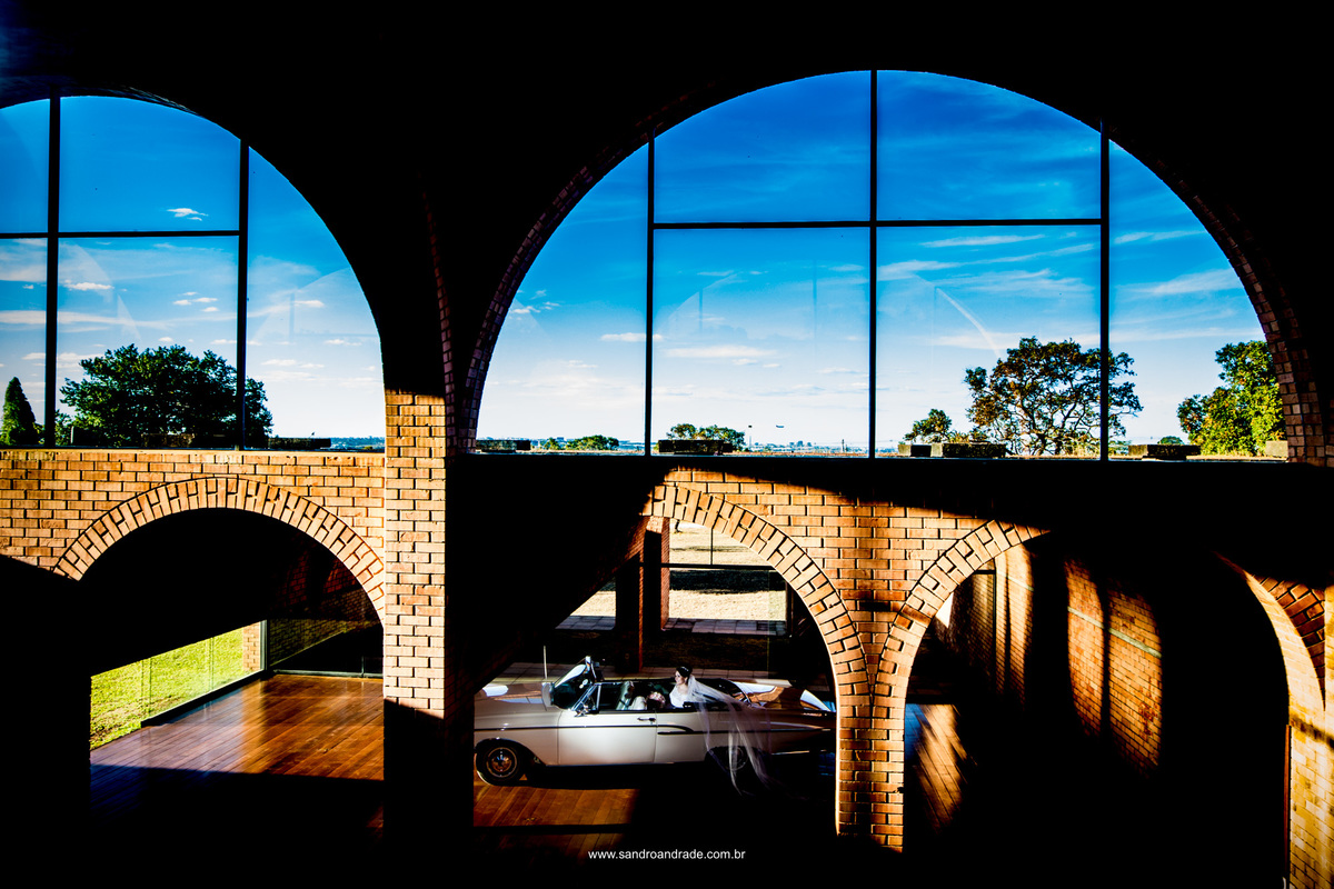 Um belo contraste, arquitetura, carro antigo e uma linda noiva.