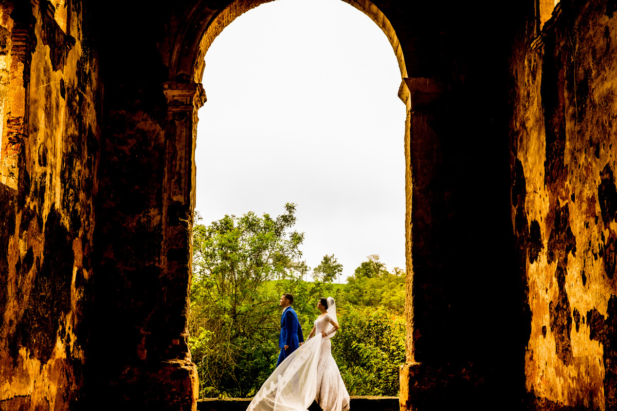 Lindos e de mãos dadas caminhando dentro das ruínas, fotografia de um colorido exuberante.