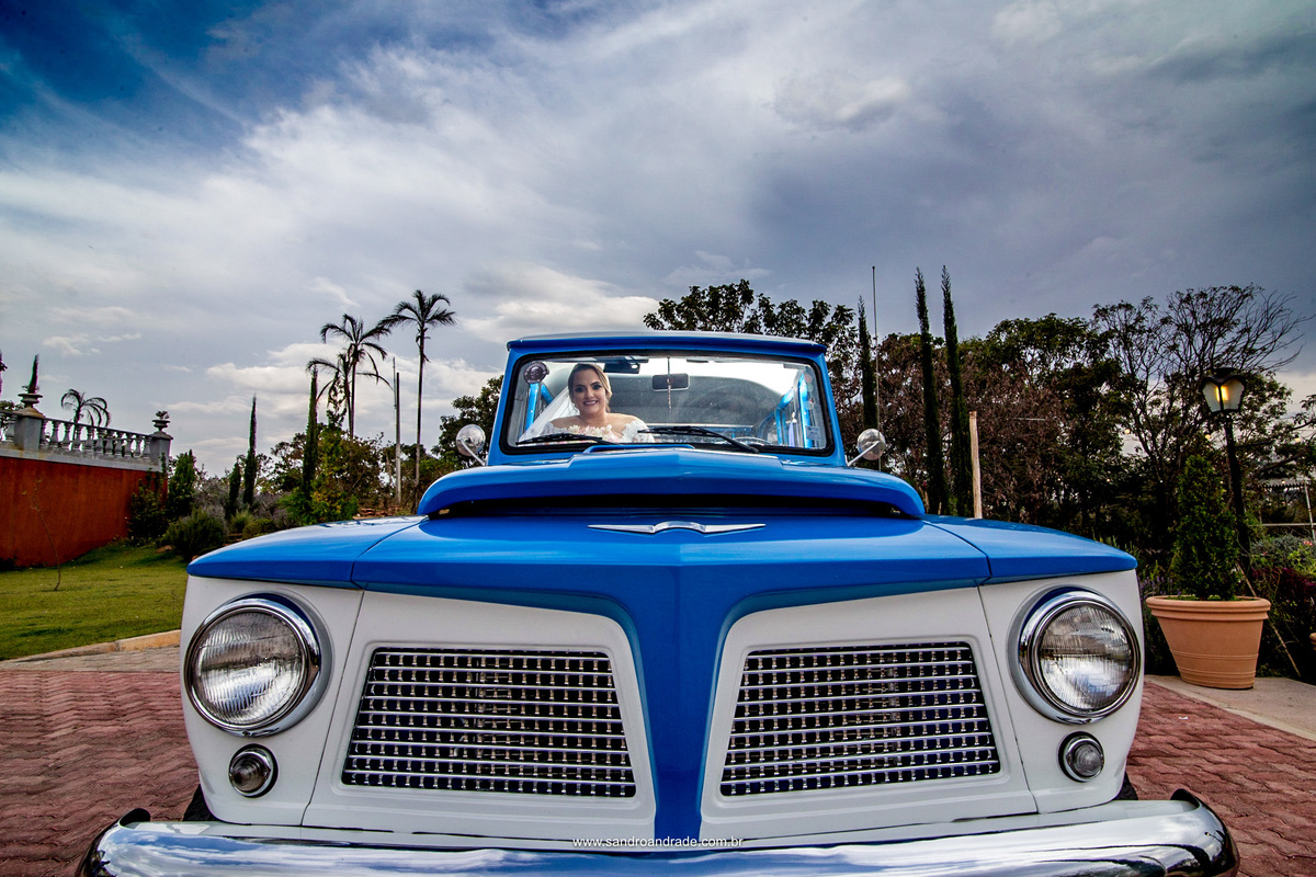 A noiva, dentro da rural dos seus sonhos, um céu azul e a linda Villa Giardini.