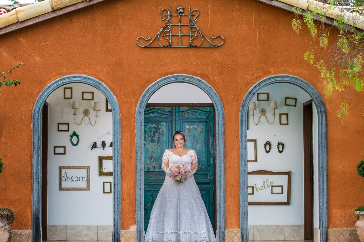 Na frente do quarto da noiva, um fotografia linda com arquitetura, cores e uma noiva lindamente ansiosa.