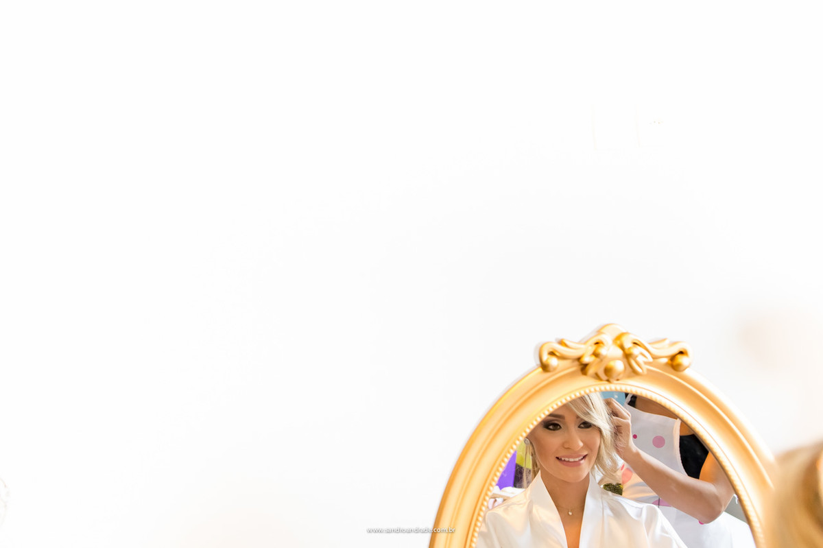 Momento da noiva fazendo seu cabelo, imagem do espelho do making of da noiva.