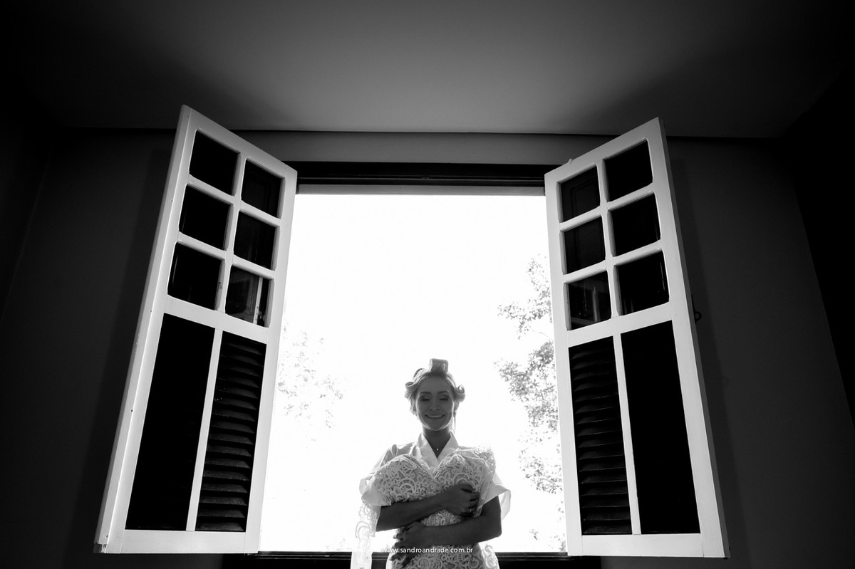 A noiva com seu lindo vestido de casamento, que esta super em alta, renda com transparência, detalhe.