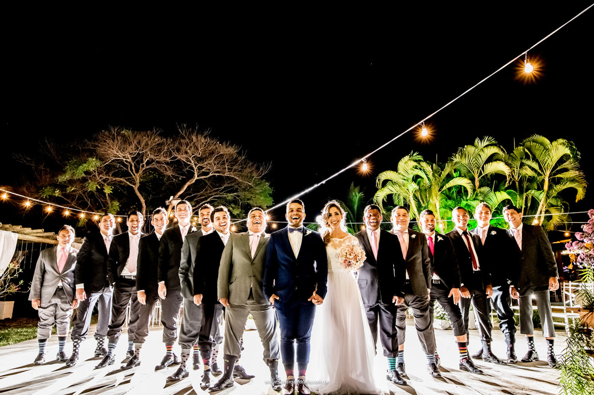 O noivo em uma fotografia descontraída com seus padrinhos e meias coloridas, com listras e de bolinhas