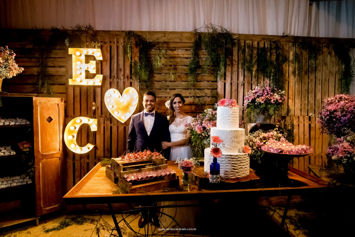 Os noivos na belíssima mesa do bolo, agora casados.