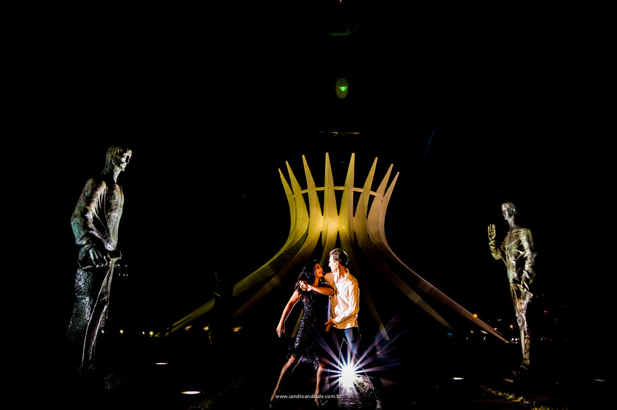 Linda fotografia dos noivos dançando, luz perfeita, fotografo criativo na frente da igreja católica catedral de brasilia