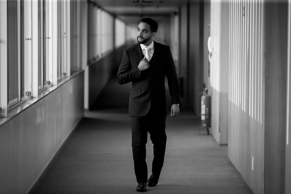 Em uma linda fotografia preto e branco, o noivo caminha pelos corredores a caminho da Paróquia Militar do Oratório do Soldado,local escolhido pelos noivos para a realização da cerimonia de casamento.