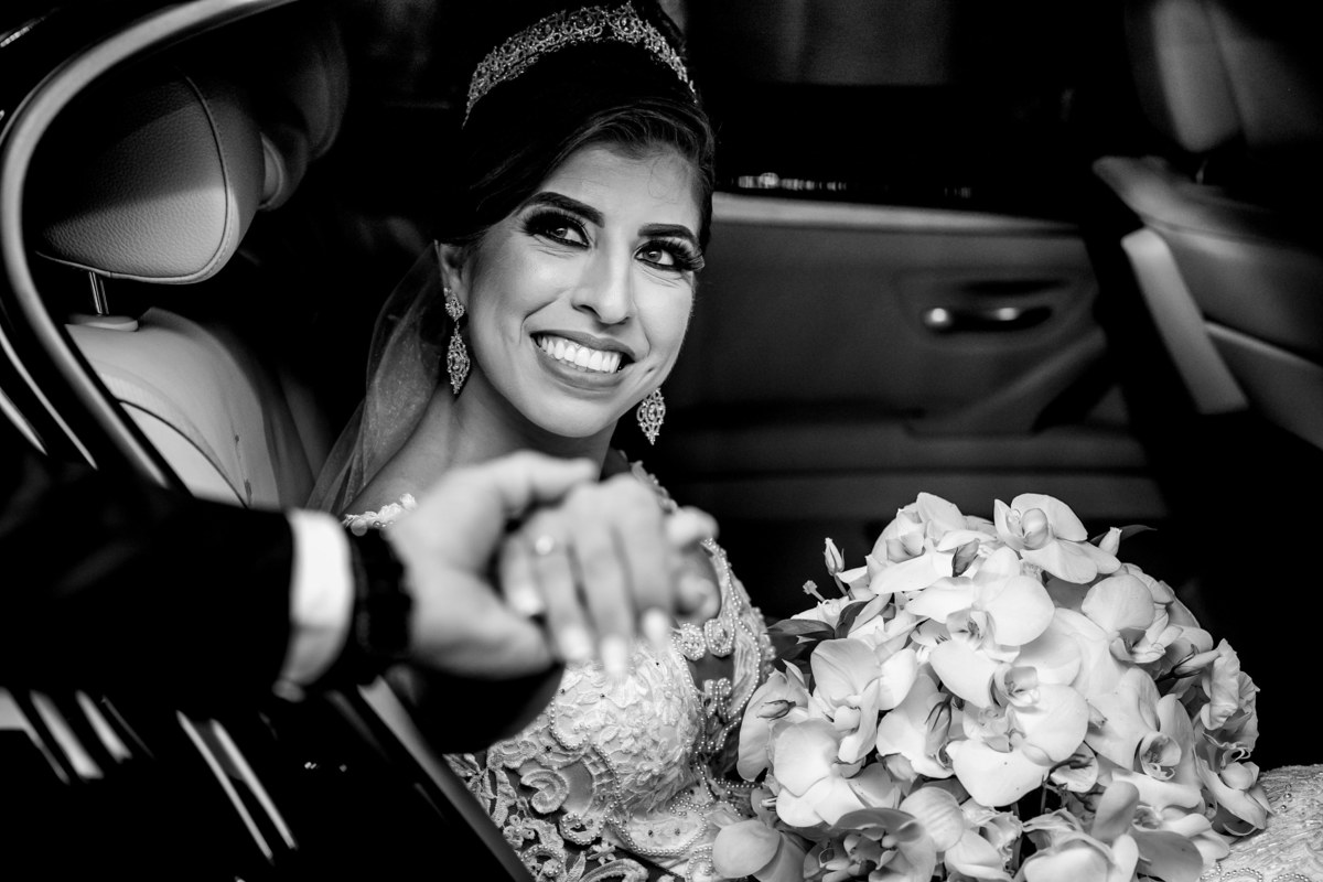 Linda e maravilhosa ela chega na igreja, dentro do carro uma fotografia preto e branco, um sorriso lindo e um lindo BMW.