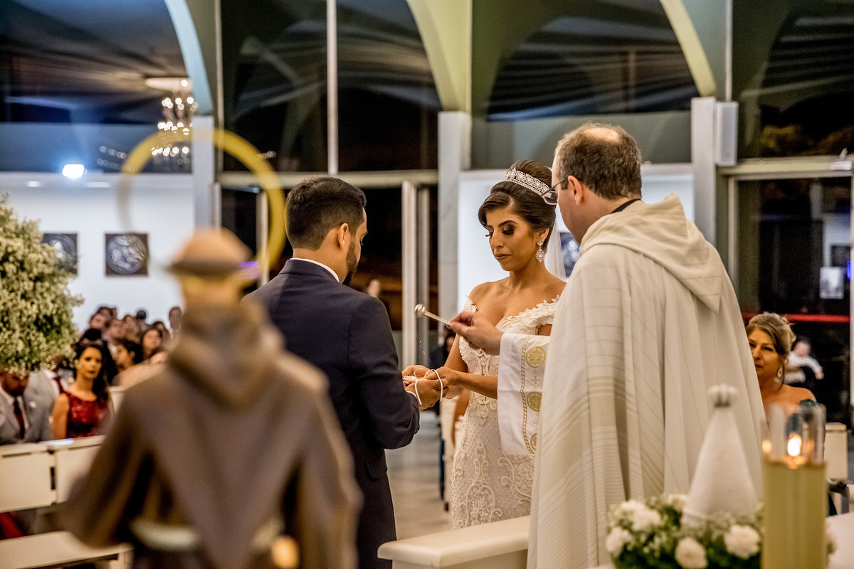 A benção das alianças, a fotografia feita no momento certo, dá para ver a agua benta respingando nas alianças.