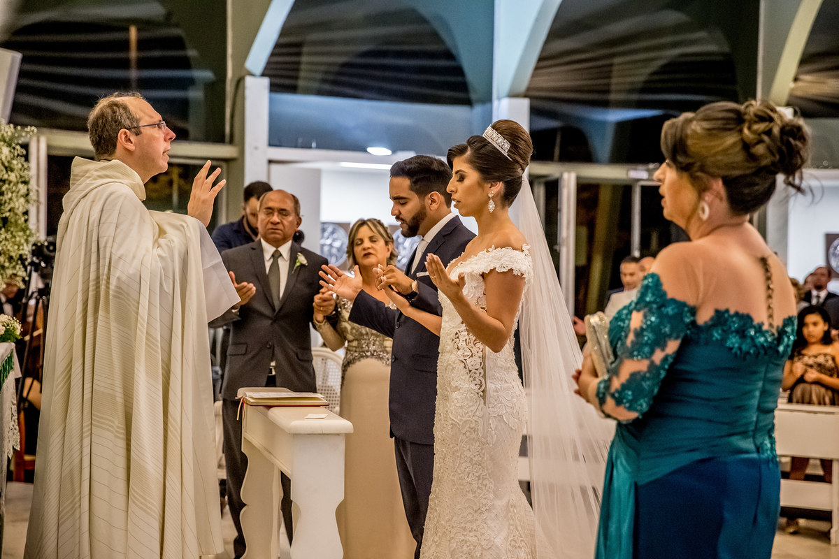 O momento da oração final, a oração universal que o SENHOR JESUS nos ensinou... padre, noivos e pais todos com as mãos erguidas abençoando a vida do casal. 
