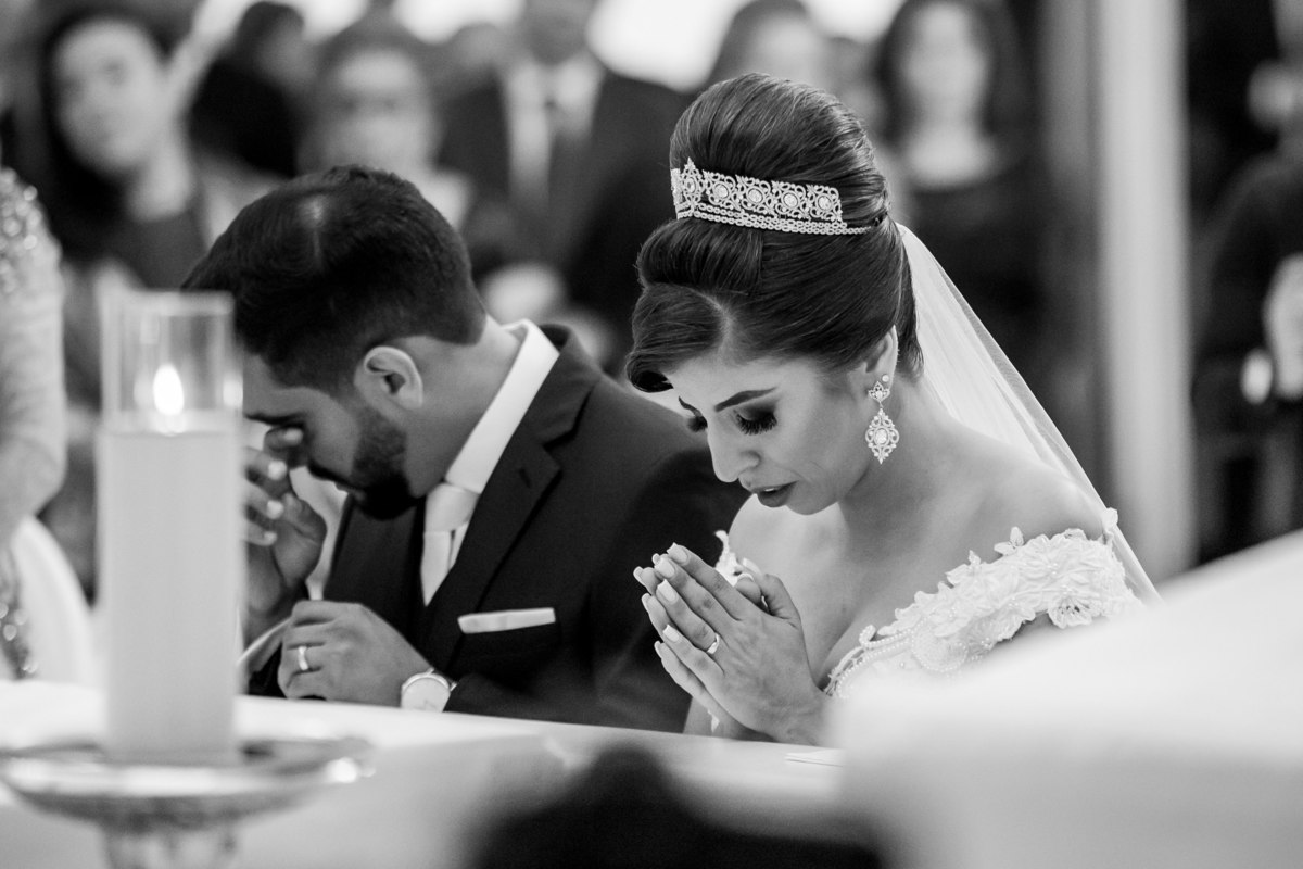 Emocionado o noivo seca sua lágrima e a noiva ainda orando.