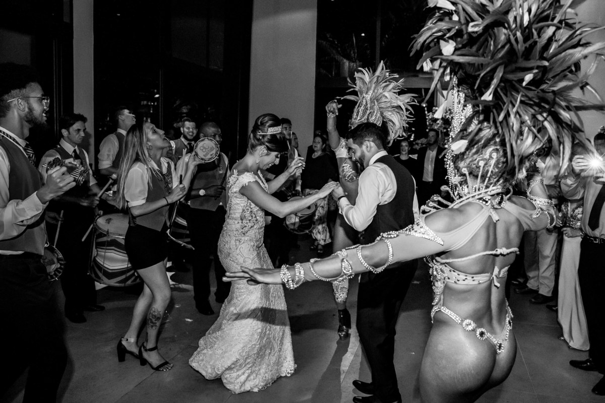 Animados, os noivos continuam sambando ao som da escola de samba.