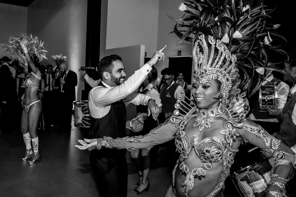 Agora é a vez do noivo, animado, sambando no meio da bateria e das passistas da Escola de Samba Brasil Capital.