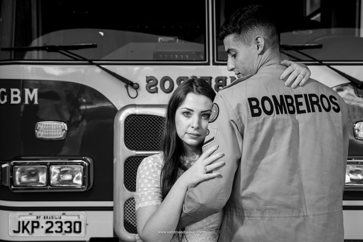 Na frente do caminhão dos bombeiros o noivo está de costas e olhando para sua amada, enquanto ela olha para as lentes de seu fotógrafo Sandro Andrade, que faz fotografia de casamento no DF. 