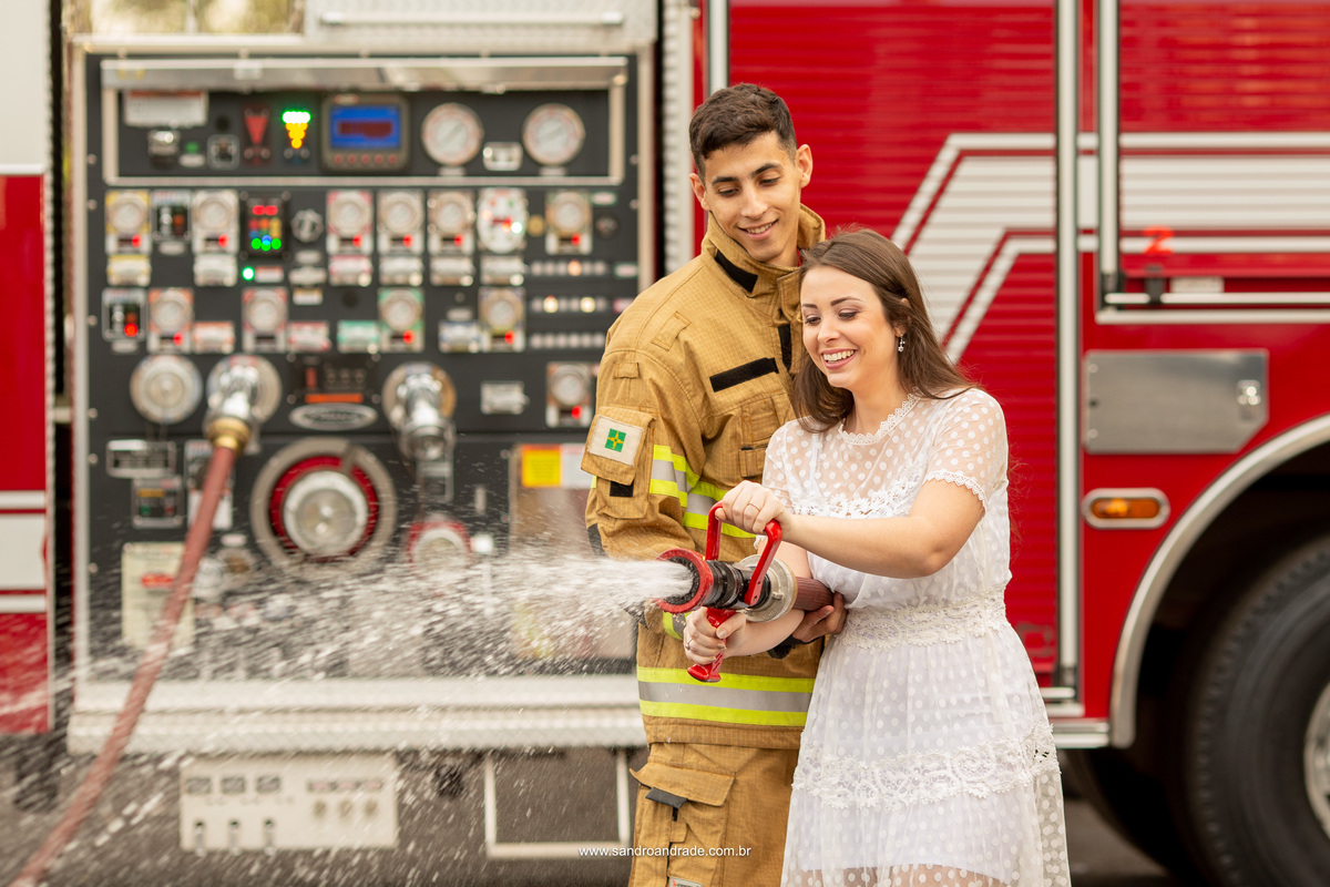 Fotografia descontraída do casal, um click inusitado enquanto ele mostra a ela como segurar a mangueira com o esguicho ligado, tudo feito pelo fotógrafo de casamento em BSB.