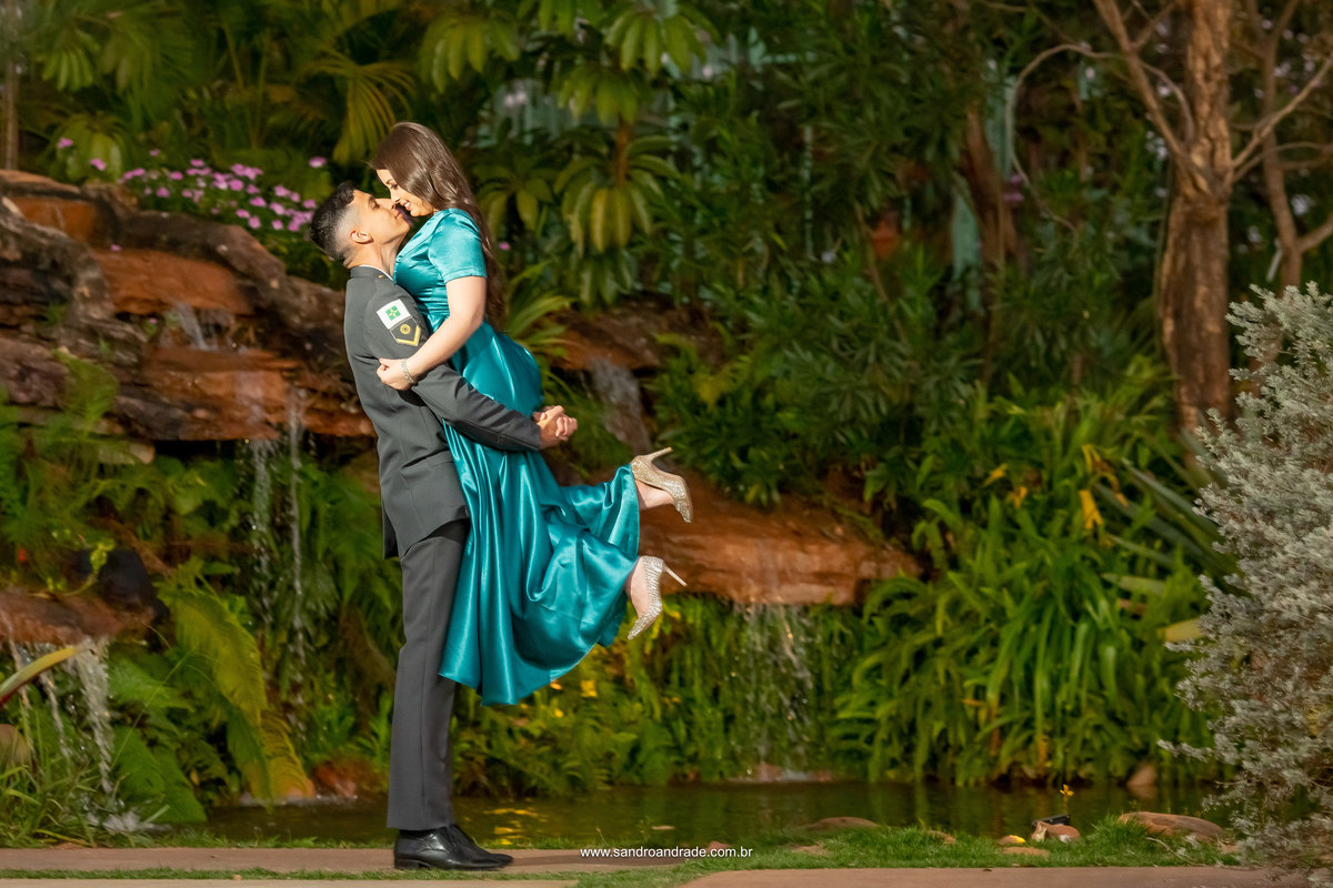 Realizando o desejo do noivo, ele se veste com a farda de gala militar e na frente da cascata ele pega sua noiva no colo, apaixonado e feliz.