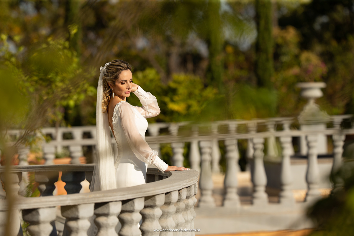 Retrato da noiva, com o verde de fundo e os detalhes, brinco, cabelo, véu e acessório.