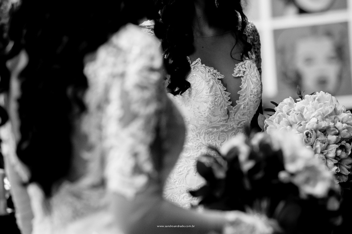 Detalhe do vestido de noiva com renda e buquet da noiva