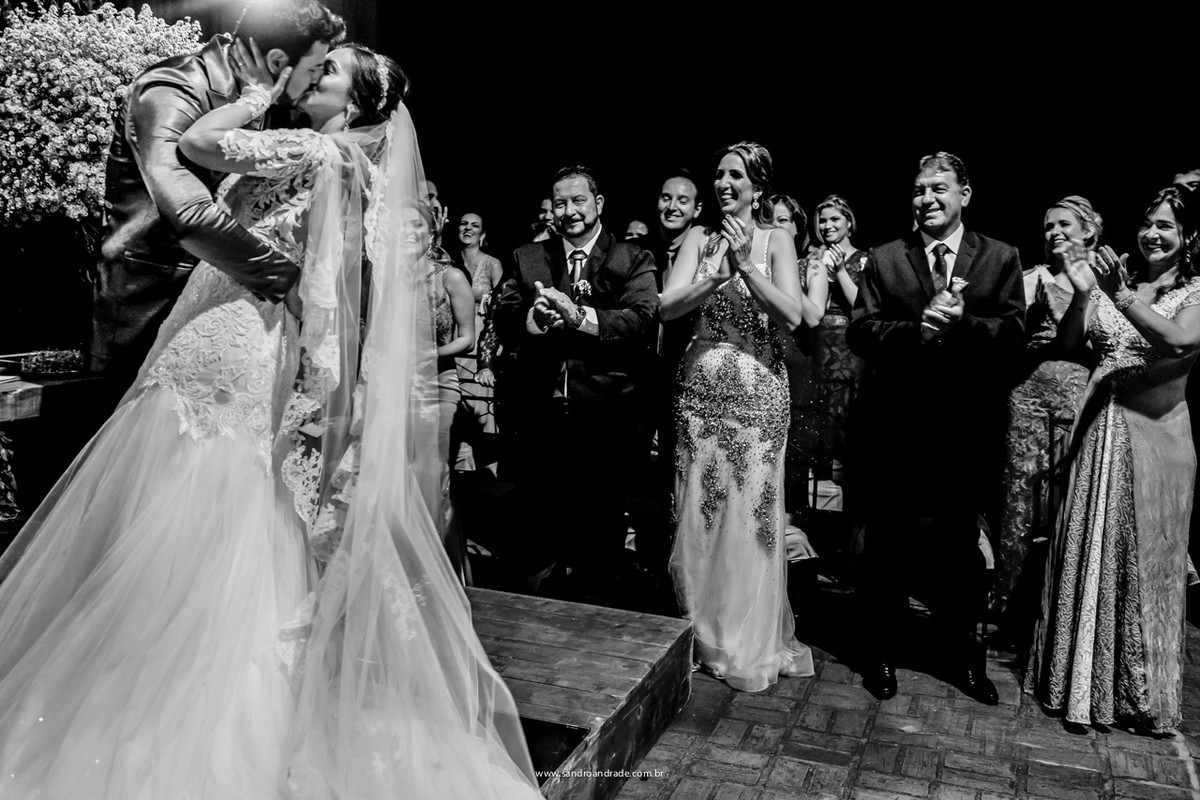 o beijo dos noivos após o sim, aplaudidos por seus familiares
