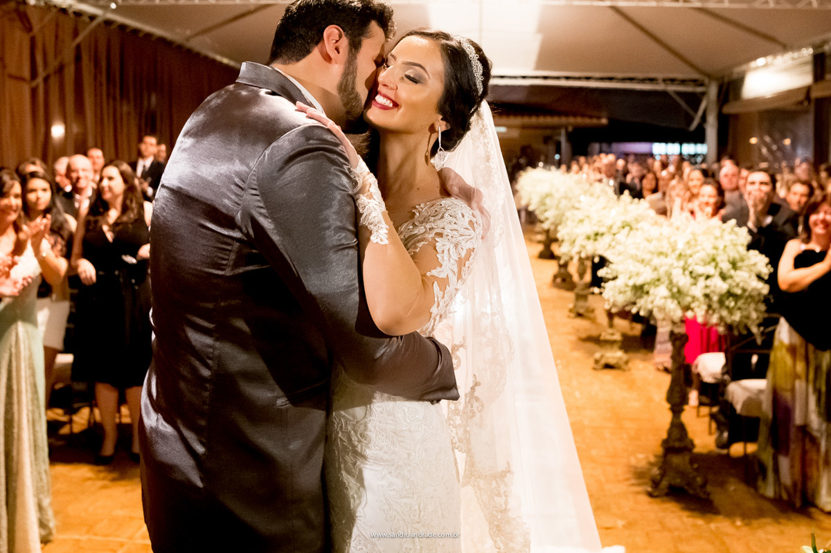 O noivo beija sua amada, na chegada ao altar