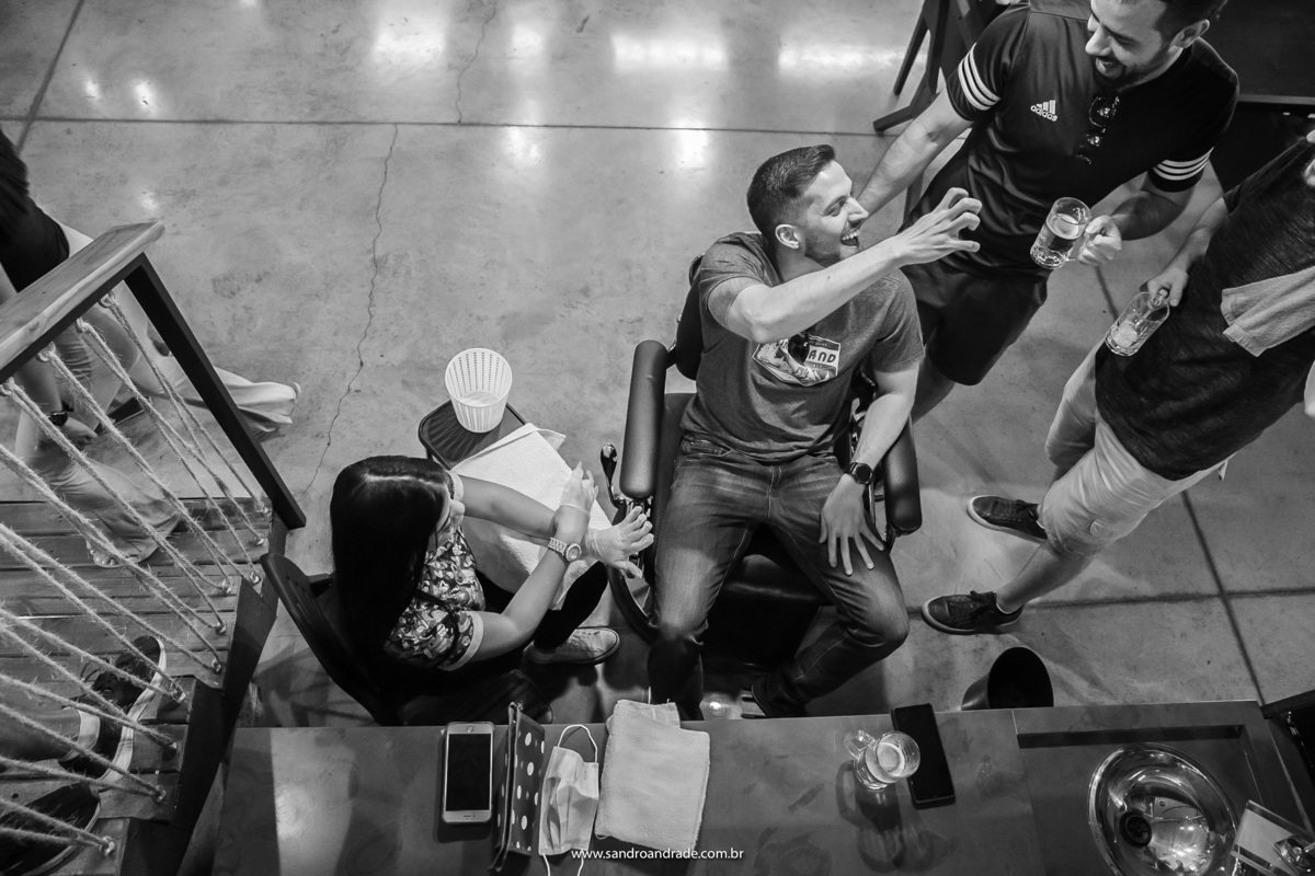 O noivo brinca fazendo mãozinha de tigre enquanto faz as unhas. 