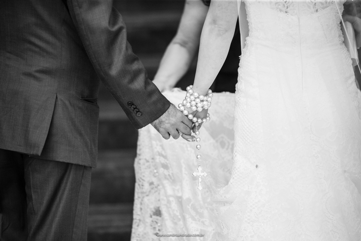 De mãos dadas ela e seu pai se preparam, para entrar na igreja.