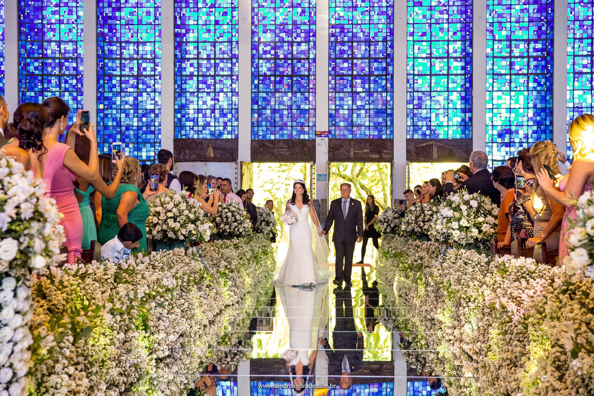 Linda entrada da noiva no santuario dom bosco, fotografia colorida mostrando os vitrais azuis dessa igreja magnifica aqui de Brasilia.