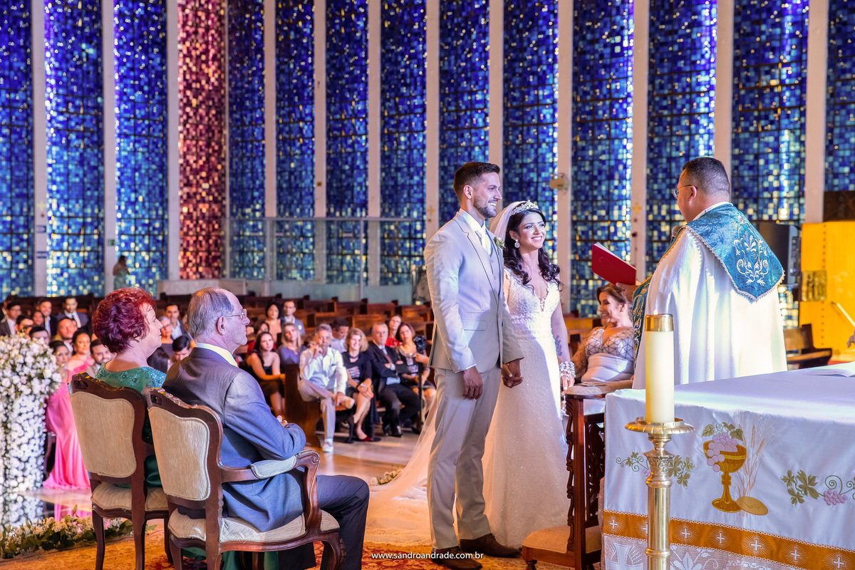 Uma fotografia simples do casal no altar durante a palavra mas que mostra toda felicidade deles.
