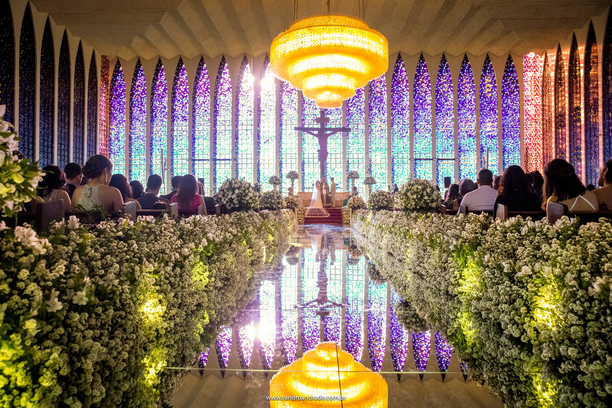 O momento do sim, minimalismo, a igreja toda sentada  e os noivos fazendo seus votos.