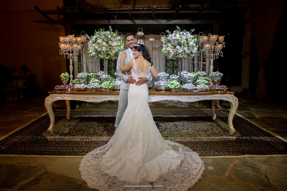 Os noivos...agora casados, posam para fotos na frente da mesa do bolo, linda fotografia.