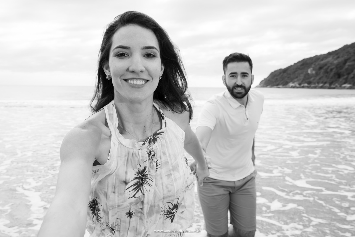 Paty da a mão ao Sandro seu fotógrafo e a fotografia fica como se ela e o Lucas estivessem correndo de mãos dadas na água do mar e como se ela tivesse feito a foto.