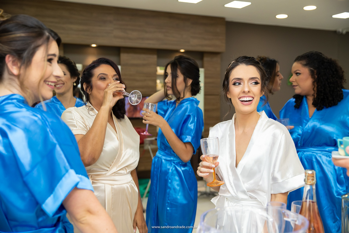 A noiva se divertindo entre as madrinhas e a mãe do noivo.
