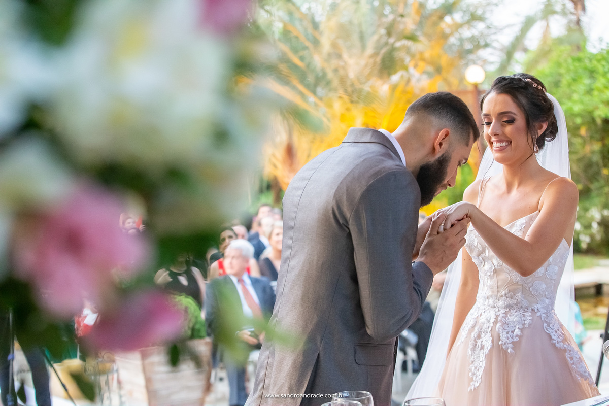 Rodrigo indo beijar a mão de sua agora esposa, após a troca de alianças.