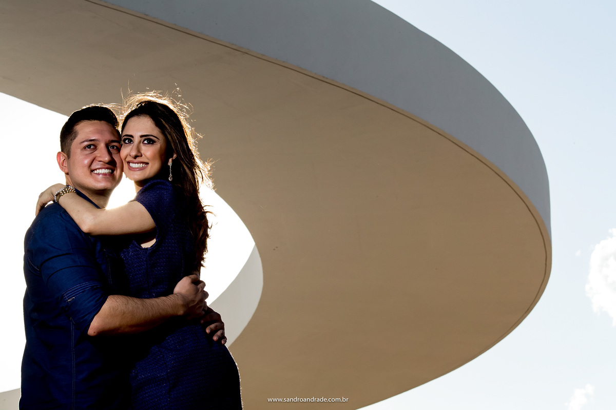 Felizes, o casal está abraço em baixo do arco do museu nacional.