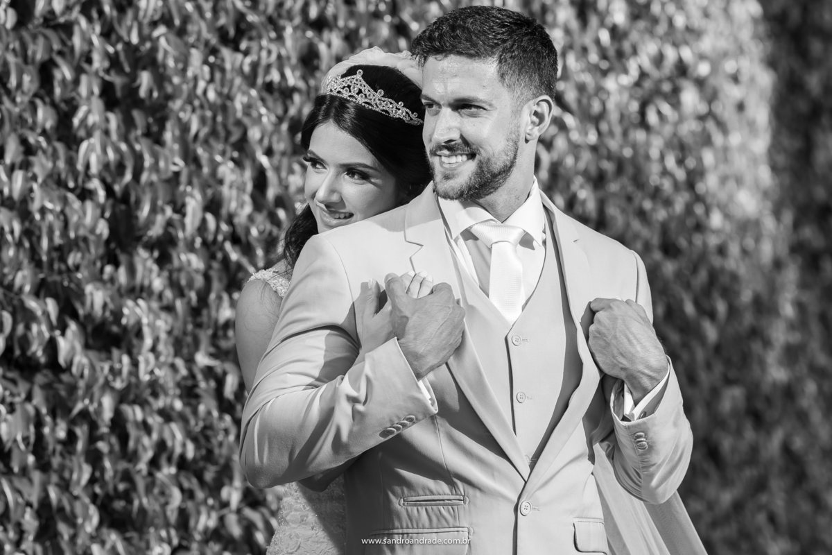 Retrato do Casal, Luiza abraça Michell pelas costas dele, enquanto ele segura carinhosamente suas mãos, uma imagem preto e branco que fala por si só.