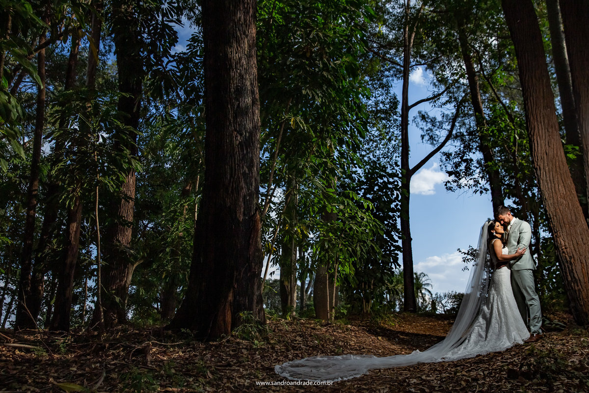 Luisa e Michell escolheram locais públicos da linda Brasília para o ensaio pós casamento deles. Nesta fotografia eles estão de frente um para outro, Luisa olha na direção da luz e Michell olha para ela, entre as árvores na Península dos Ministros. 