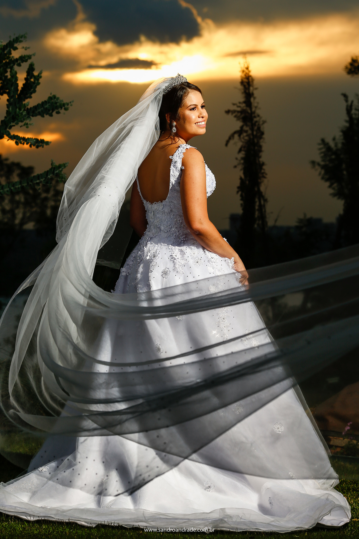 Antes de tirar o véu da noiva, fizemos este lindo retrato da noiva, de costas, com um sorriso no rosto, véu voando e todos os detalhes deste belo vestido do estilista Fernando Peixoto.