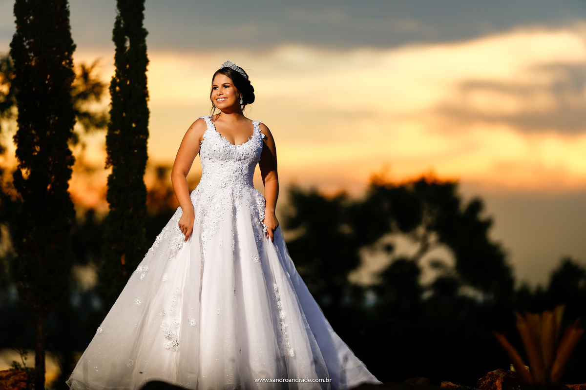 Retrato da noiva, sorrindo e um belo por do sol no fundo, quase no finalzinho, mas lá majestoso.