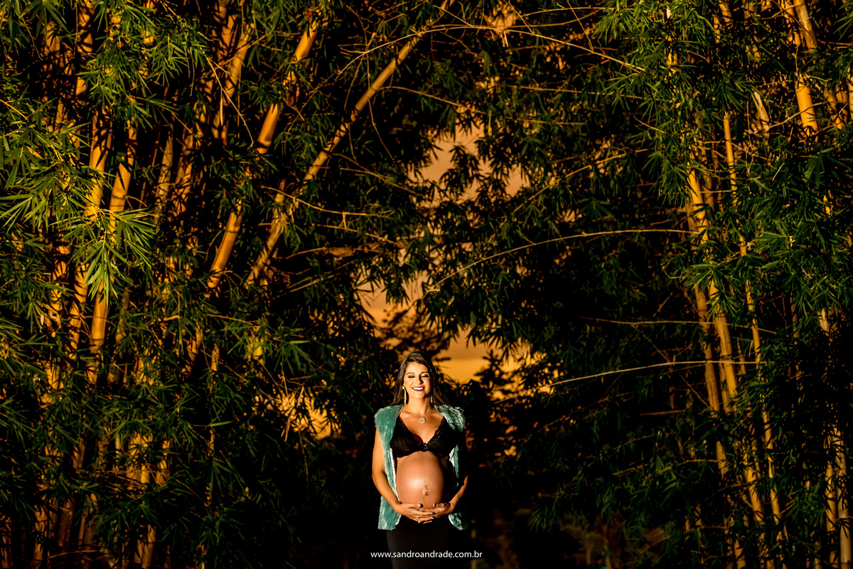 Feliz ela segura a barriga com as duas mãos, fecha os olhos e sorri pensando em seu bebê que está para chegar.