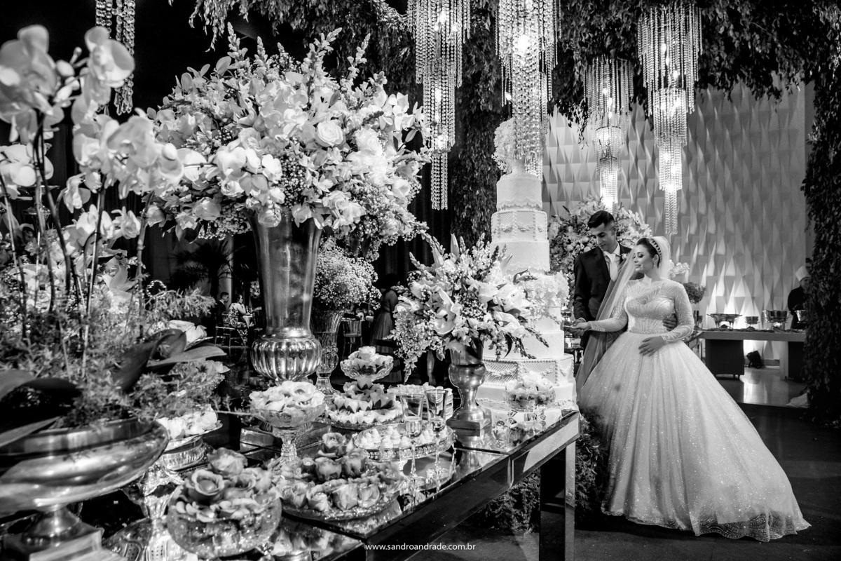 Uma fotografia preto e branco, ainda do corte do bolo, linda demais.