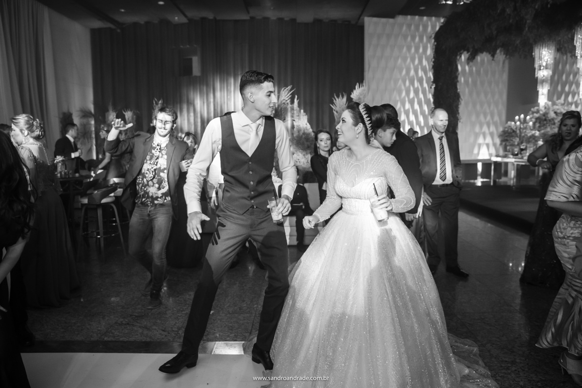 O casal dançando na pista, muito empolgados e felizes.