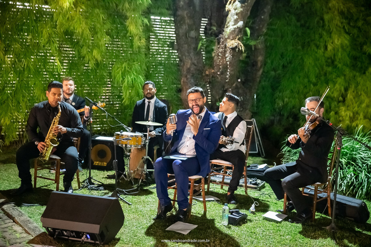 O músico Davi Ramiro soltando a voz junto com sua banda, antes de começar a cerimonia.