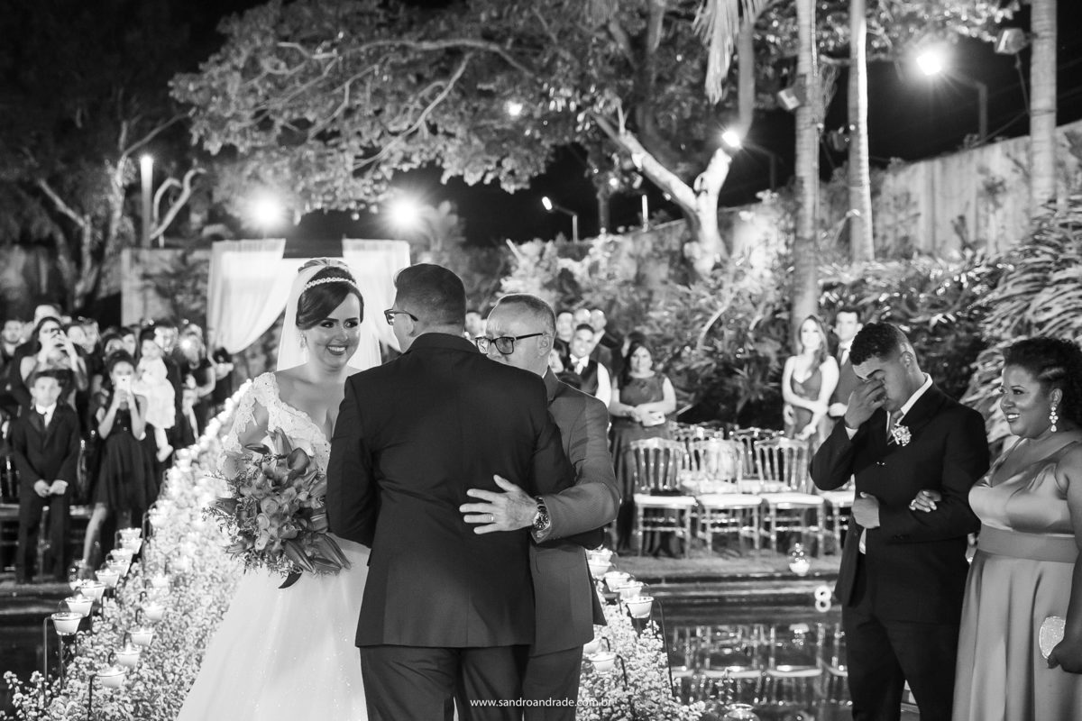 O momento da entrega, o pai da noiva o abraça e emocionado ele só olha para sua noiva.