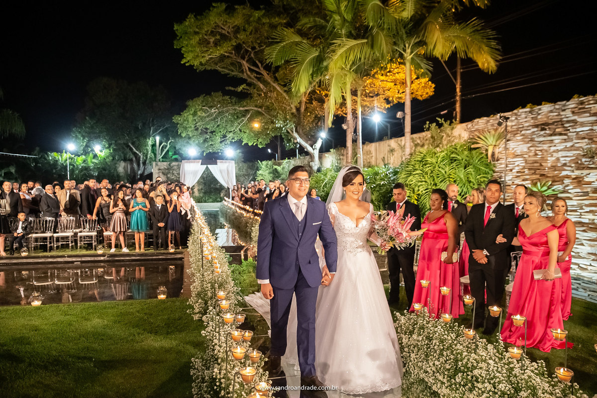 De mãos dadas eles seguem para o altar, sob os olhares de todos os convidados.