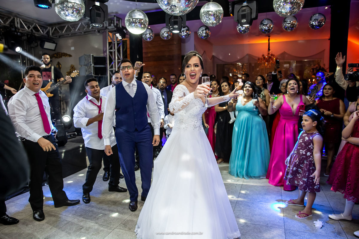 A noiva no centro com o noivo atrás e todos os convidados ao redor.